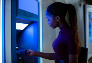 black woman inserting her card at atm